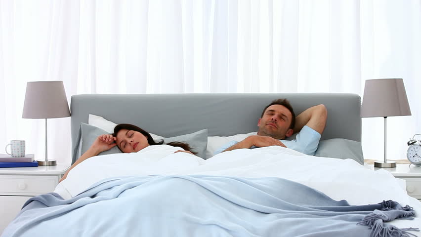 Children jumping on their parents who are lying in the bed at home