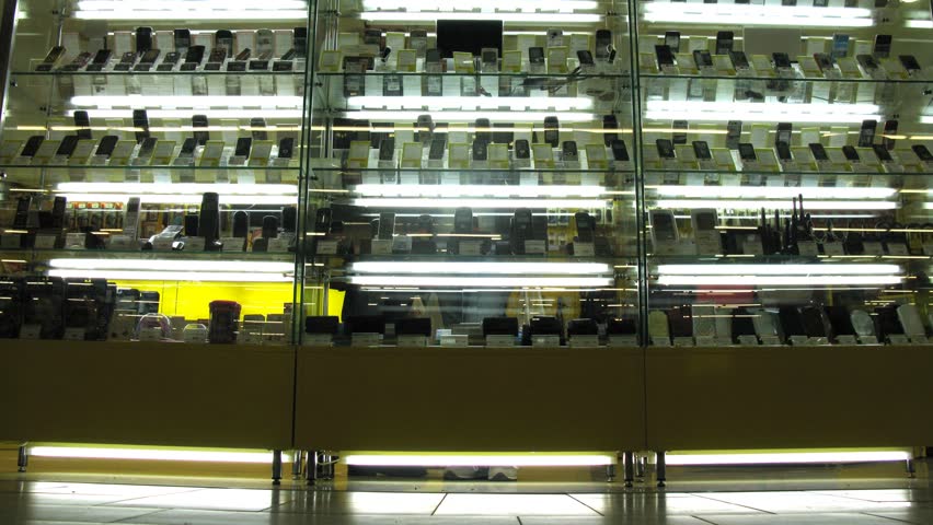 People passing by cell phone showcase, time lapse   