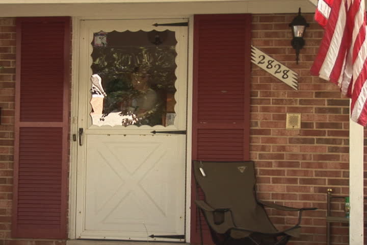 NTSC: Woman and dog walks out of home. She sits down and starts reading a newspaper