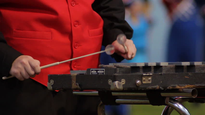 Close up of a marching band member playing a xylophone.