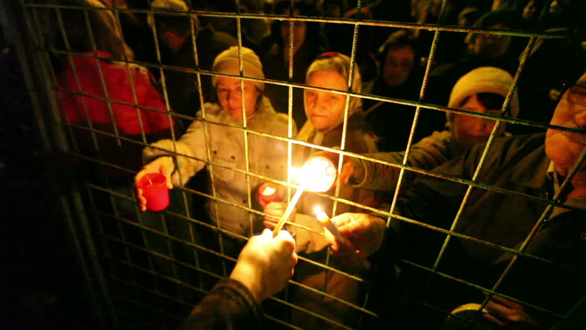 BUCHAREST, ROMANIA: APRIL 4: Large crowds of people share the Holy Light through an iron fence on Easter Night, April 4, 2010 in Bucharest, Romania. 