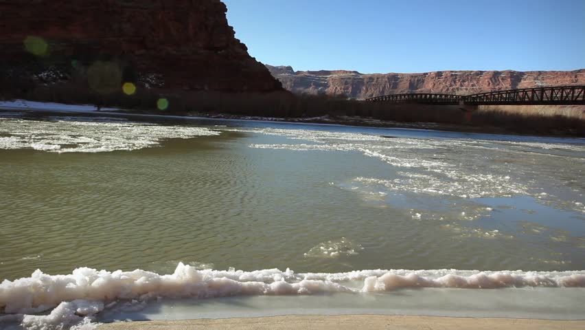 Frozen winter Colorado river and bridge Moab Utah