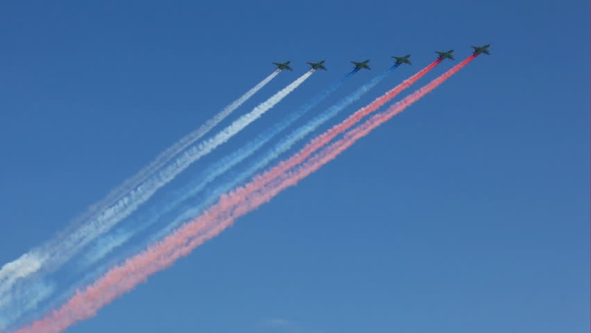 MOSCOW - MAY 9: armored subsonic attack planes Su-25 fly in sky leaving trail of smoke as tricolor Russian flag on parade in honor of Great Patriotic War victory on May 9, 2010 in Moscow, Russia. 