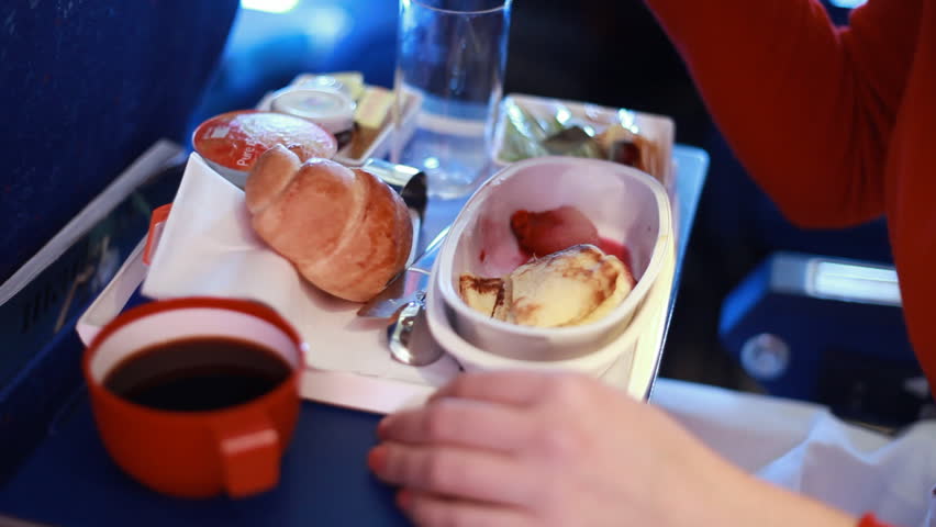 tray with food on airplane, woman's fork selects a slice of meat