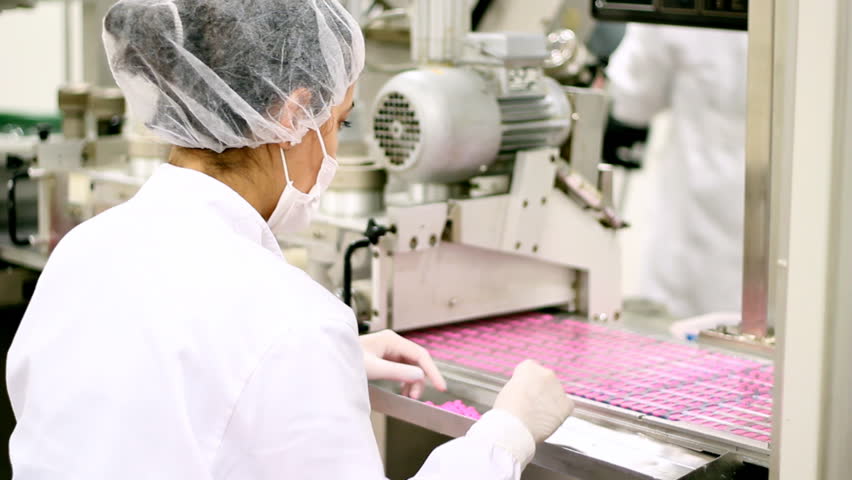 Pills in pharmaceutical blister pack packaging moving on the conveyor belt. 