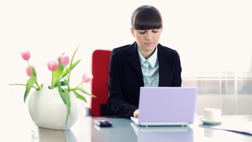 Young businesswoman working on laptop on reflective table