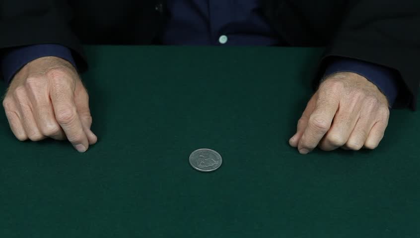 Magician changes a silver dollar to a penny.