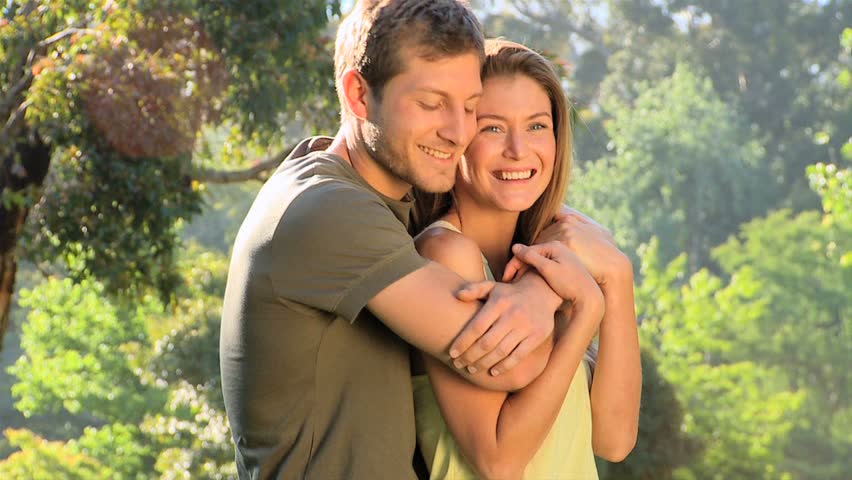 Attractive couple cuddling outdoors in a park