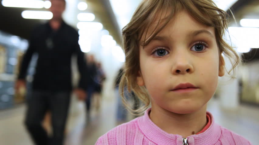 cute little girl stands inside subway, then wind from moving train blows her hair, closeup