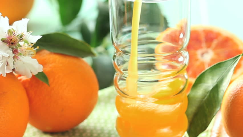 close up of glass filling up with orange  juice, zoom-out