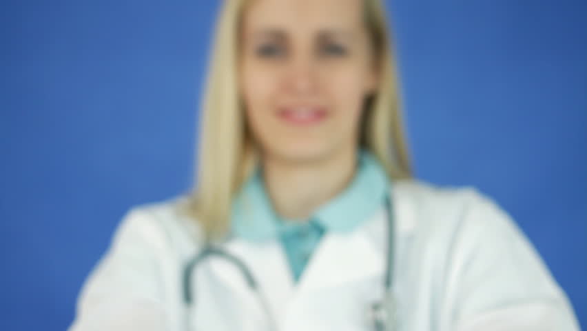 Female doctor hand offering pills on blue background 