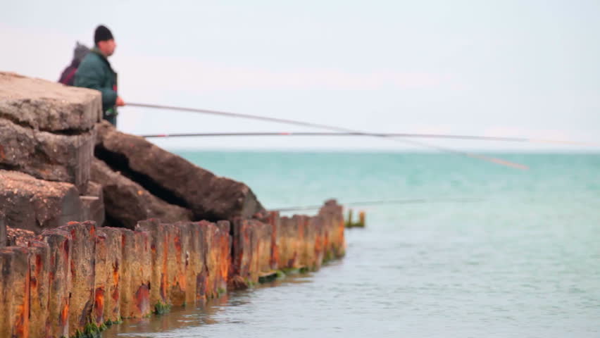 Two fishermen on an old rusty pier