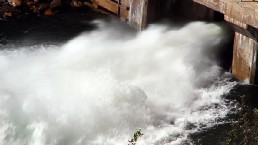 High flood waters are being released through the dam.