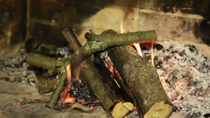 Simple brick fireplace with fire logs burning out to give heat