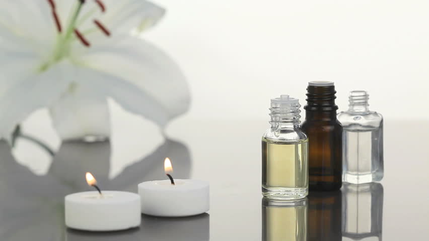 Lighted white candles near lotion flasks in a Spa center
