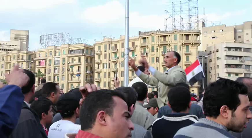 CAIRO - CIRCA JAN 2011: Man guides protesters in Tahrir Square, circa January 2011, Cairo, Egypt. Tahrir Square was the focal point of the 2011 Egyptian Revolution where demonstrations grew to 250,000 plus people by day 6, January 31, 2011.