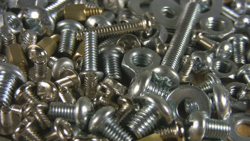 Orbiting shot of screws on a workbench. Shot in 1080HD at a high angle with shallow depth of field, blurred background.