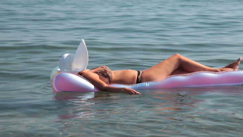 unrecognizable woman in bikini relaxing on raft 