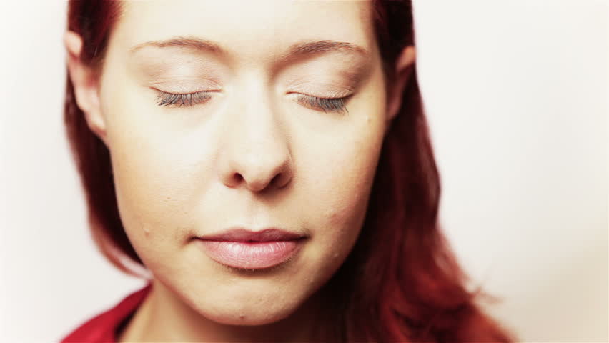 Young redhead woman opening slowly her eyes