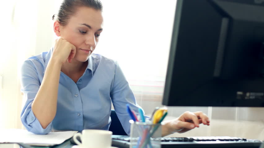 Bored businesswoman sitting at her desk in the office
