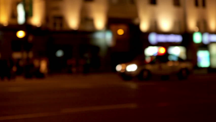 A police car with lights on driving through an empty street