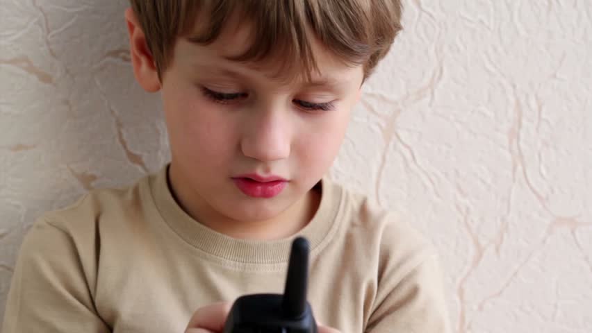 Little boy hold phone with antenna dials number and try to speak