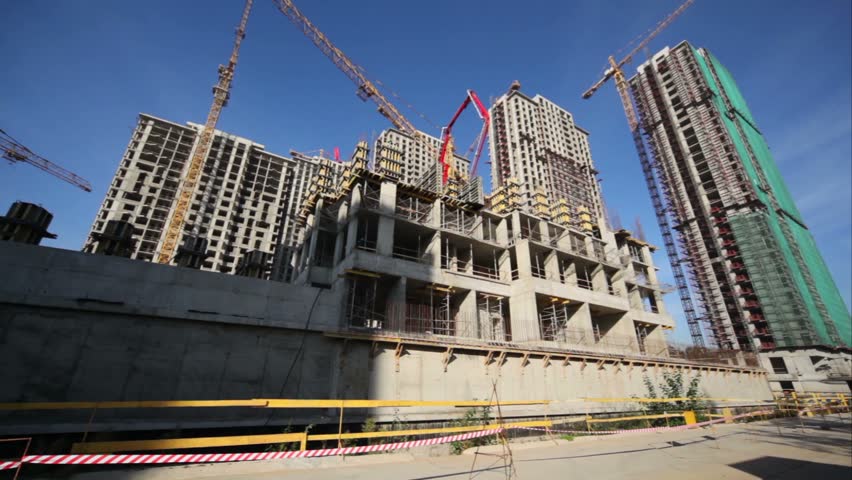 MOSCOW - SEPTEMBER 27: Red tipper ride on road in front of houses construction site, September 27, 2010 in Moscow, Russia. otal investment in commercial real estate in Russia in January-June 2011 doubled in yearly terms reaching 1.77bn euros. 