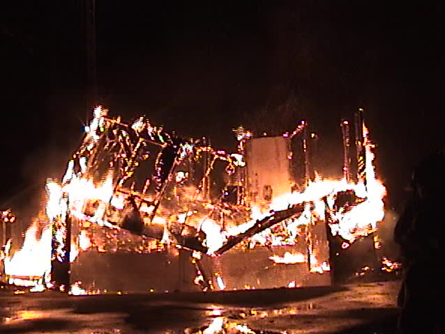 Structure fire at night with the building collapsing.