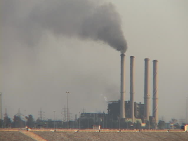 An Iraqi power plant, with only one smokestack working, spews smoke over Baghdad.