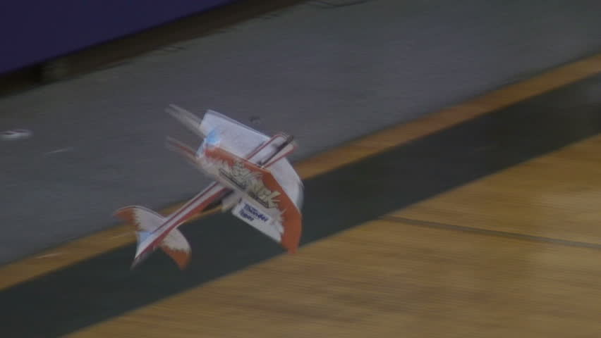 Radio-controlled foam model airplane performing aerobatic tricks at the competition venue