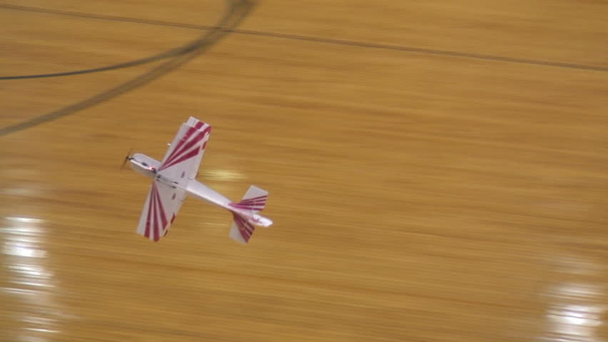 Radio-controlled foam model airplane performing aerobatic tricks at the competition venue
