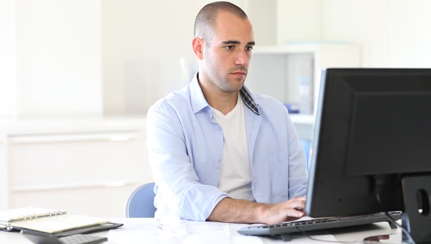 Office worker typing report on computer