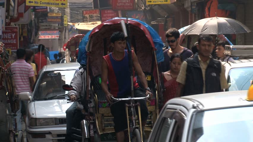 KATHMANDU - CIRCA 2010: People, cars and bikes circulate through the city circa 2010 in Kathmandu.