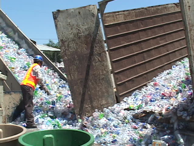 Thousands of plastic bottles are unloaded at a recycling center.