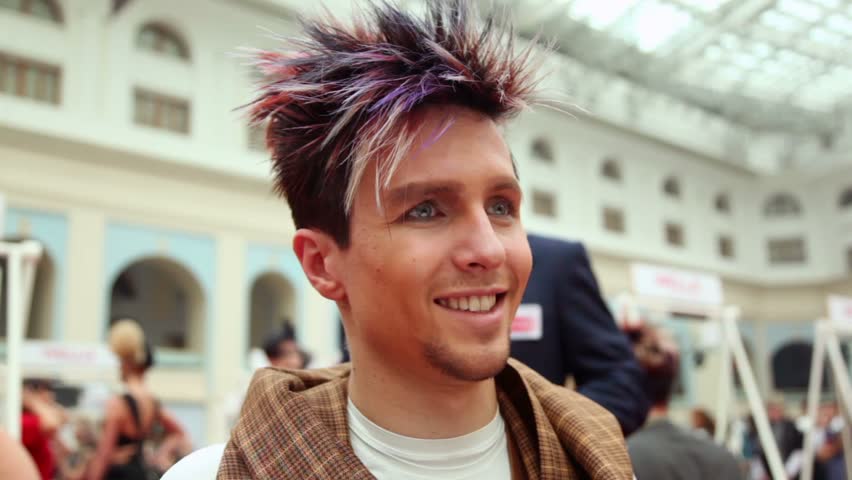 MOSCOW - OCTOBER 2: Smiling man with original hairstyle with violet strand at XVII International Festival World of Beauty 2010 in exhibition complex Gostiny Dvor, on October 2, 2010 in Moscow, Russia.