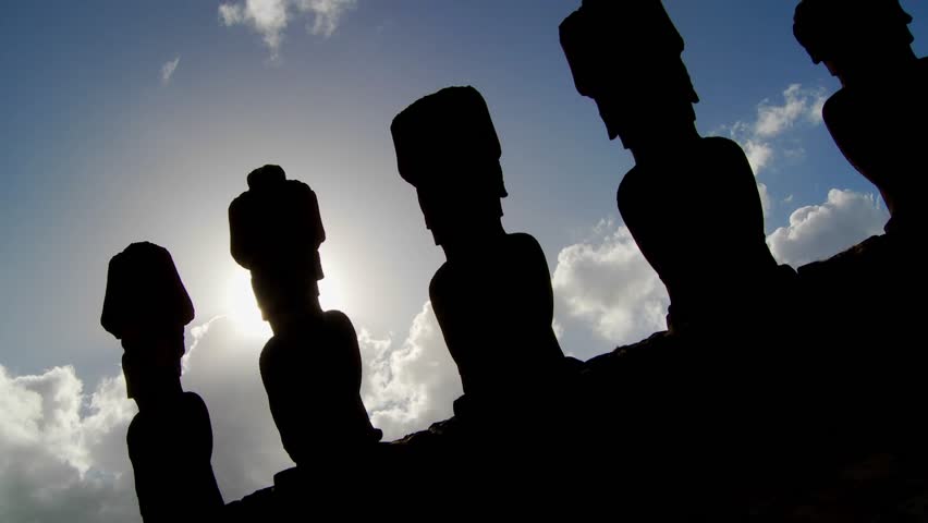 Easter Island statues are silhouetted against the sky.