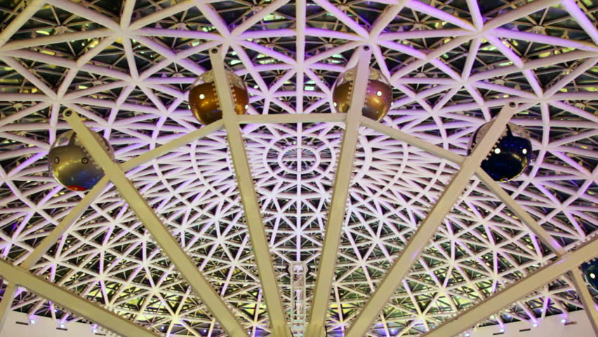 big ferris wheel with flashing lights under arch of roof at nightclub