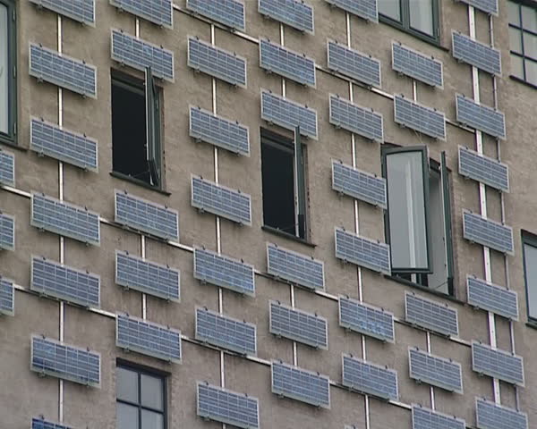 Building wall with lot of solar collectors. Renewable ecological energy. 