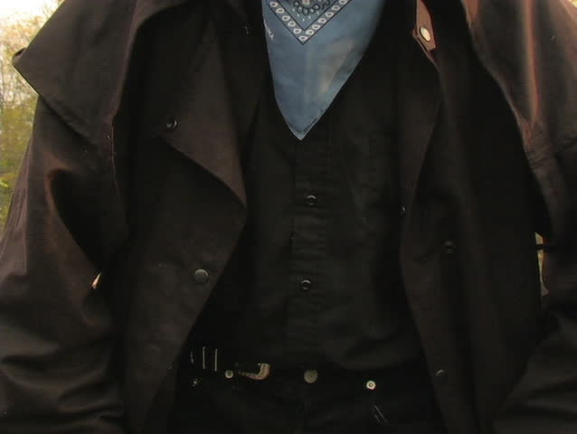 A COWBOY ENTERS THE FRAME AND GIVES AN INTIMIDATING STARE.