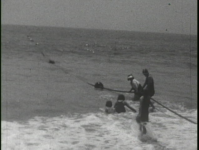 CALIFORNIA, USA - CIRCA 1930s: People mill around cars and an old biplane in this home movie circa 1930s in California, Usa.
