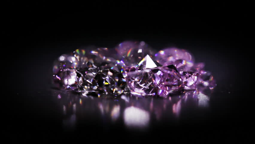 Jewel stones heap in violet tones rotating over dark background