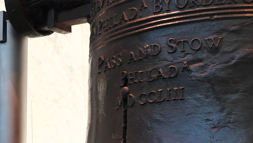 The camera pans down from the names of the founders who cast the Liberty Bell, John Stow and John Pass, to the crack beginning at the bottom.