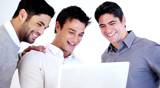 Portrait of happy male executives working on laptop together over white background