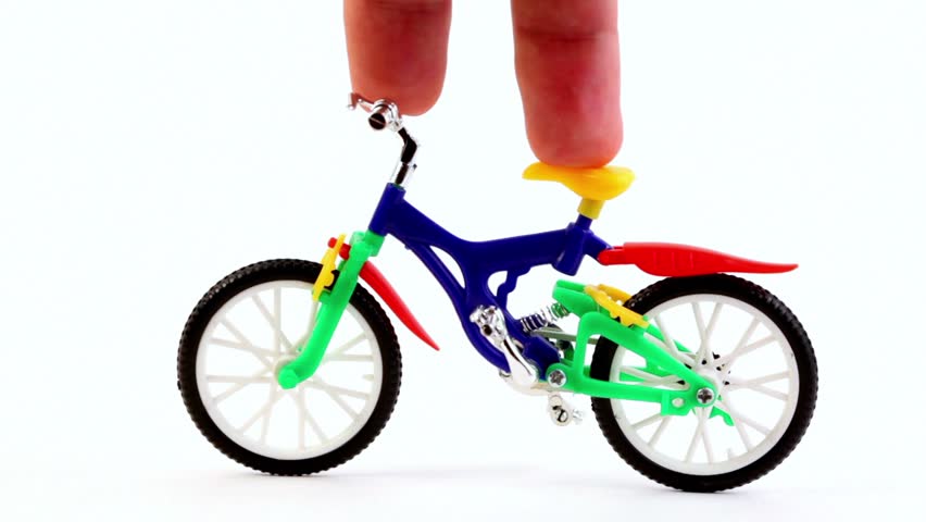 Fingers on toy bike, rotates handlebars, and then ride away