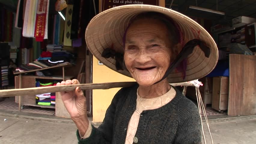 VIETNAM - CIRCA 2009: An old woman missing one eye smiles and holds her hand out circa 2009 in Vietnam.
