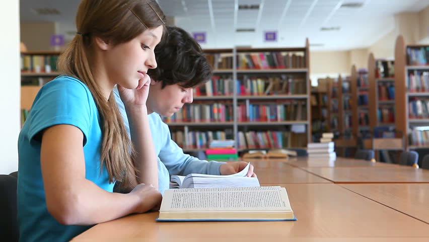 Two teens studying at library 