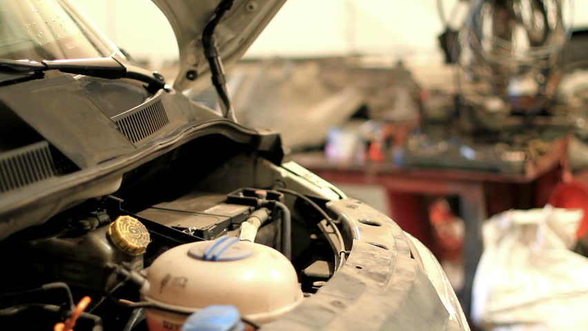 technician removes the expansion tank on the car. 