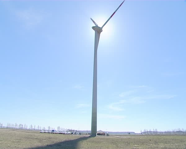 Sunlight penetrating through rotating windmill wings. Renewable wind energy. 