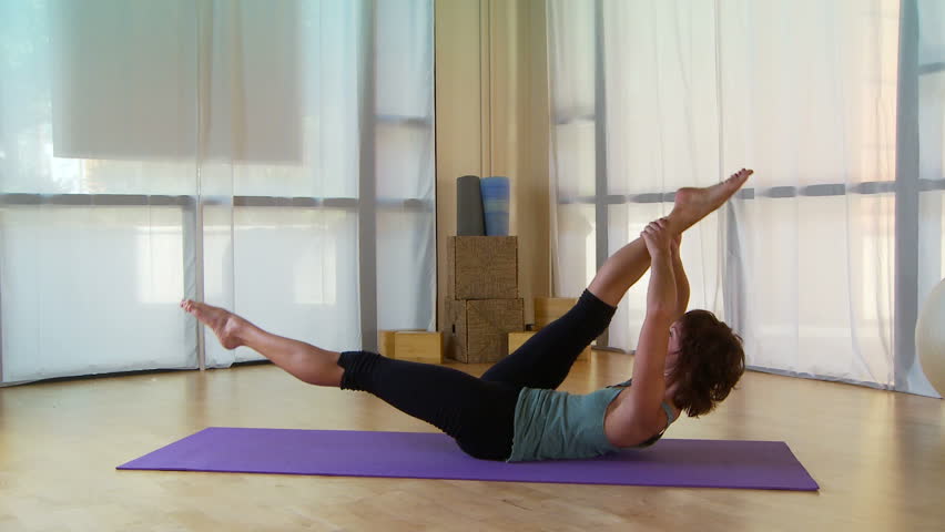 Young woman performing pilate move on a mat