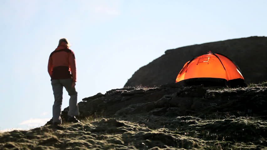 Female Hiker by Tent on Barren Mountainside